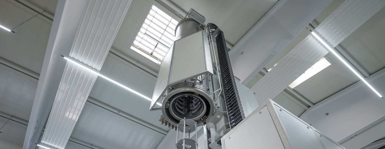 Das Bild zeigt einen kundenspezifischen, ausgefahrenen Hochvakuum-Lötofen der PINK GmbH Vakuumtechnik. Dieser wurde für das GSI-FAIR-Forschungsprojekt konzipiert und gefertigt. Europas größter Hochvakuum-Lötofen, gebaut von PINK Vakuumtechnik