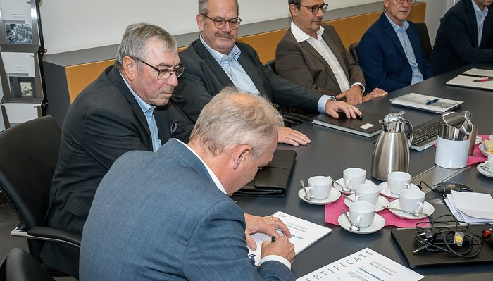 Die Geschäftsführung unterschreibt einen Vertrag